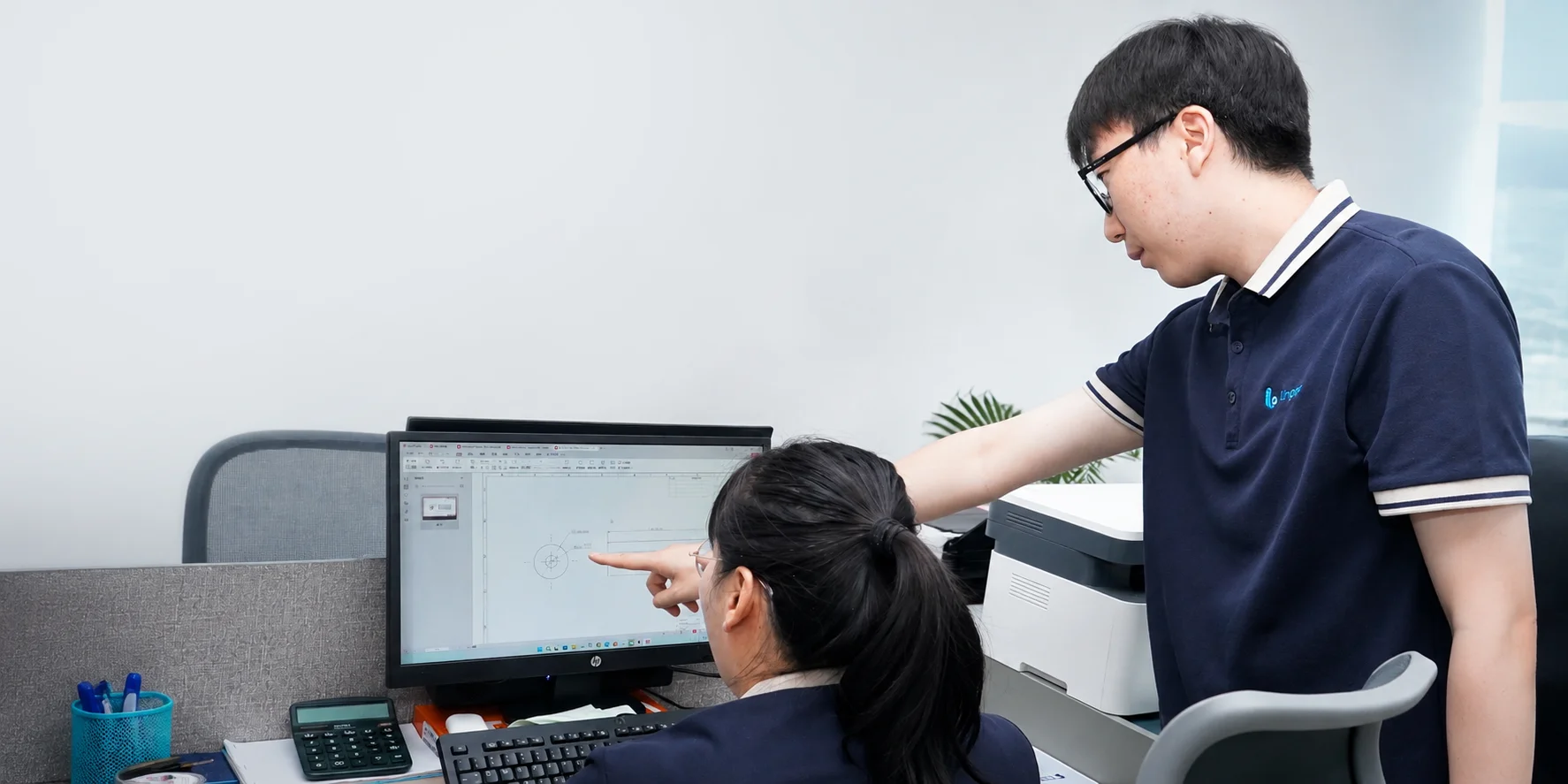 Our team reviews product information and drawings at a computer, discussing product specification details.