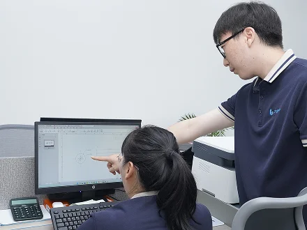 Our team reviews product information and drawings at a computer, discussing product specification details