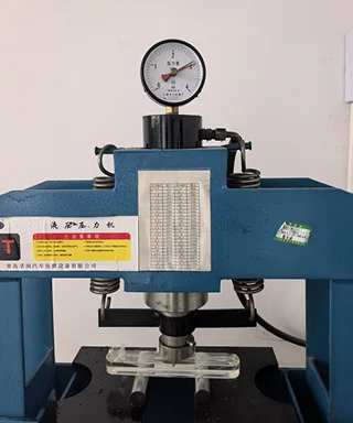 Industrial glass sample undergoing strength testing on equipment