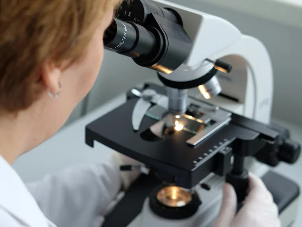 Laboratory technician in protective clothing adjusting protective gloves