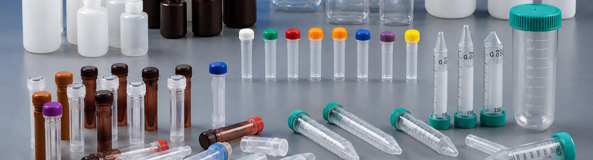 Disposable centrifuge tubes and sample tubes in various sizes arranged on a laboratory bench.