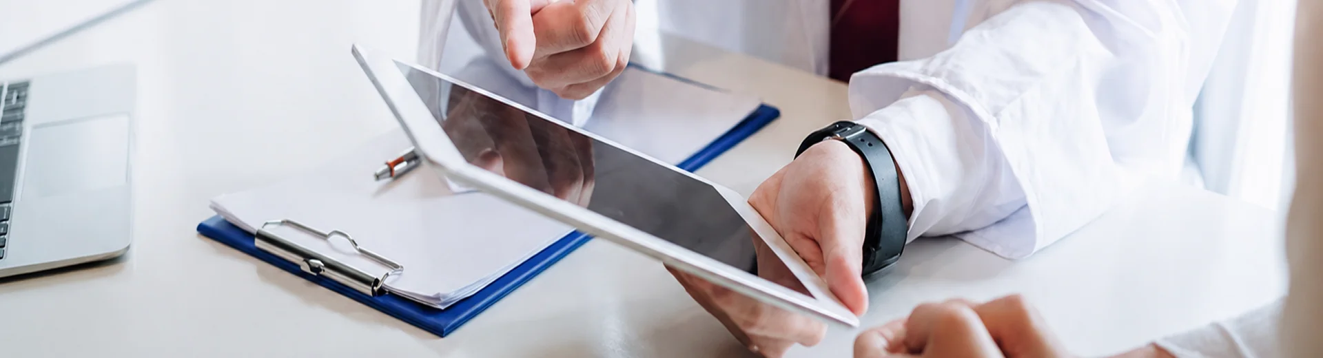 A staff member uses a tablet to review information and select products.