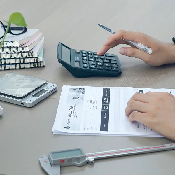 Staff reviewing quotation documents and using a calculator for price calculation.